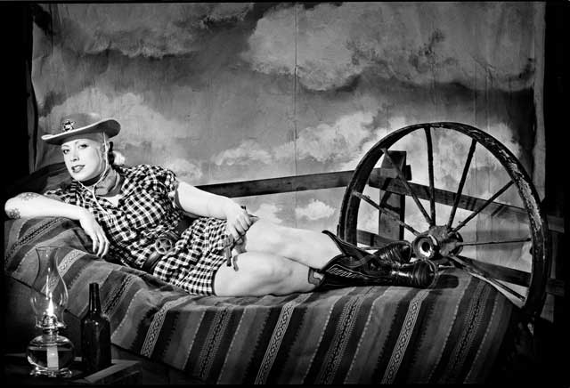 Cowgirl pinup on the open range. Staged portrait.