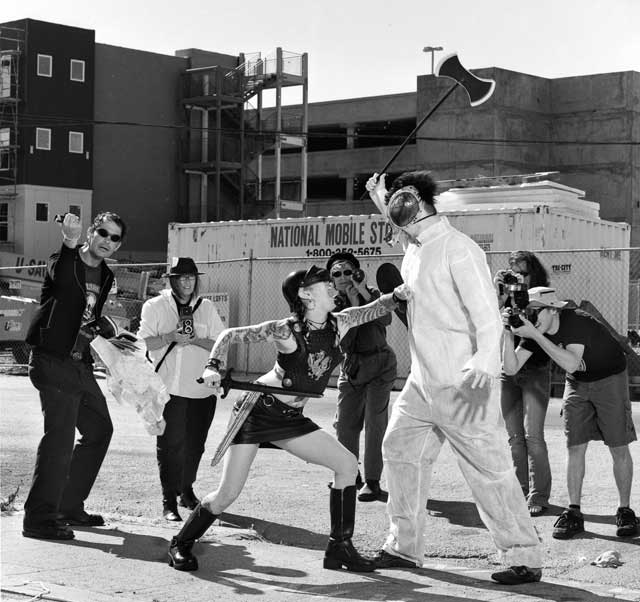 Warrior woman battling a giant half-human half-animal monster - paparazzi are recording the event