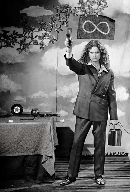 Portrait of a man in a suit holding a paint brush